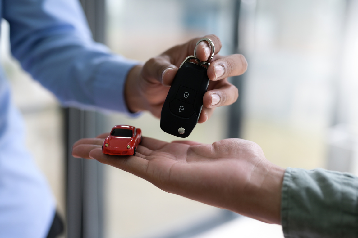 Exchanging car keys and model cars, Finance concept.