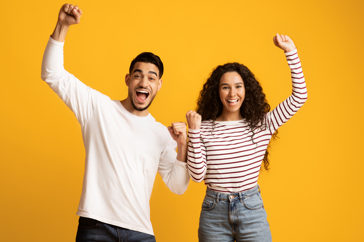 Lucky Winners. Cheerful Excited Middle Eastern Couple Celebrating Success with Raised Fists